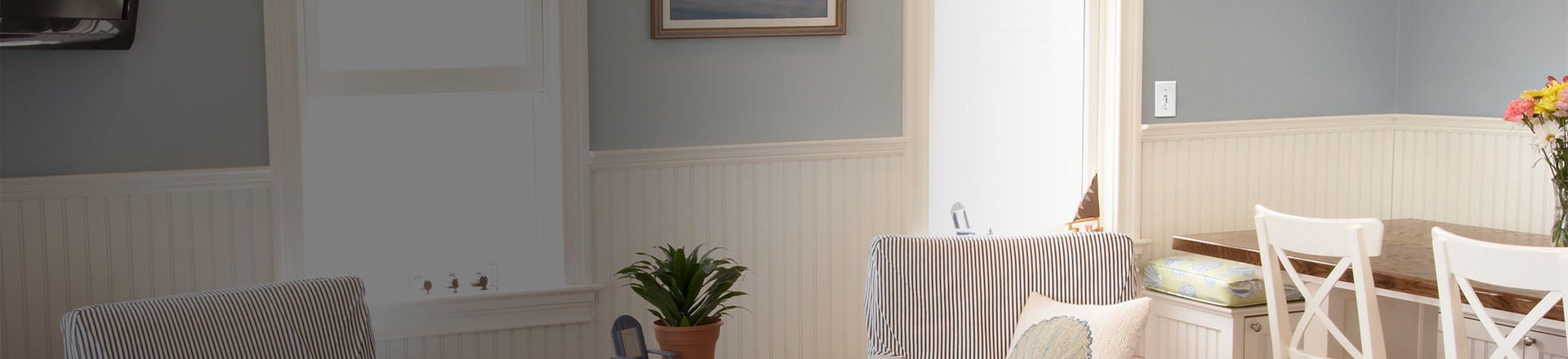 salle à manger de couleur pâle avec gradateur à glissière à levier sur le mur à côté d’une fenêtre