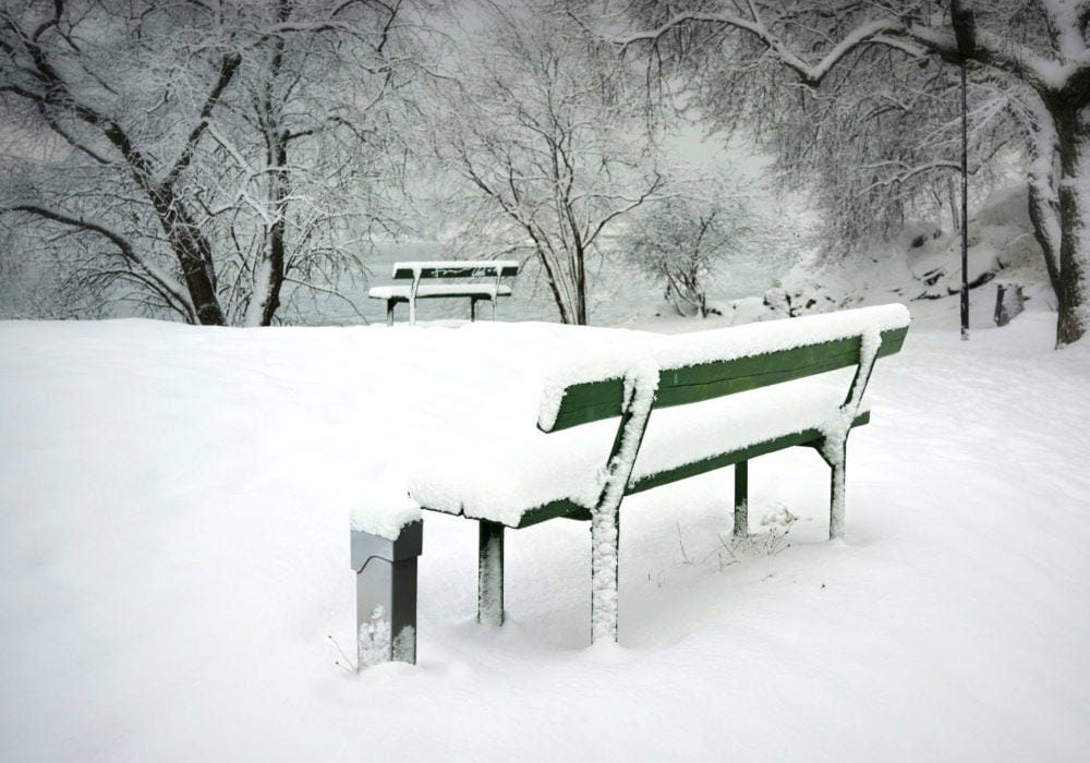 Socle d'alimentation à côté du banc recouvert de neige